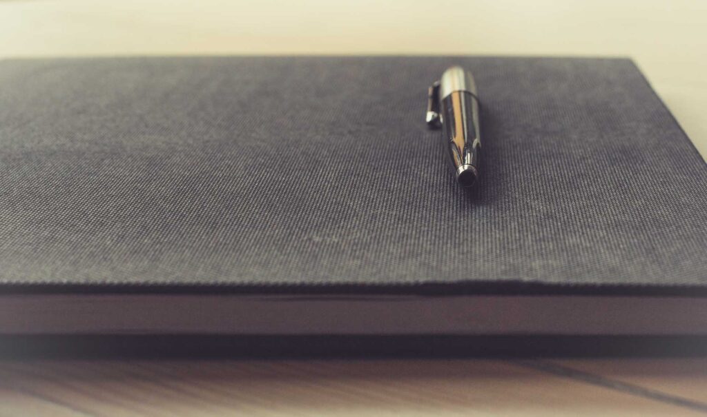 A pen resting on top of a notebook